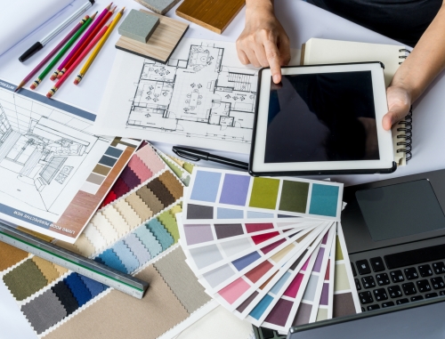 a person considering colour swatches for decorating 